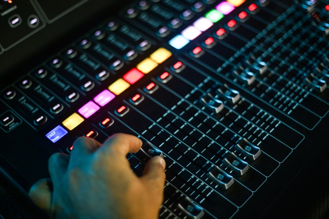An MGNS sound engineer operating a digital mixing console during an event